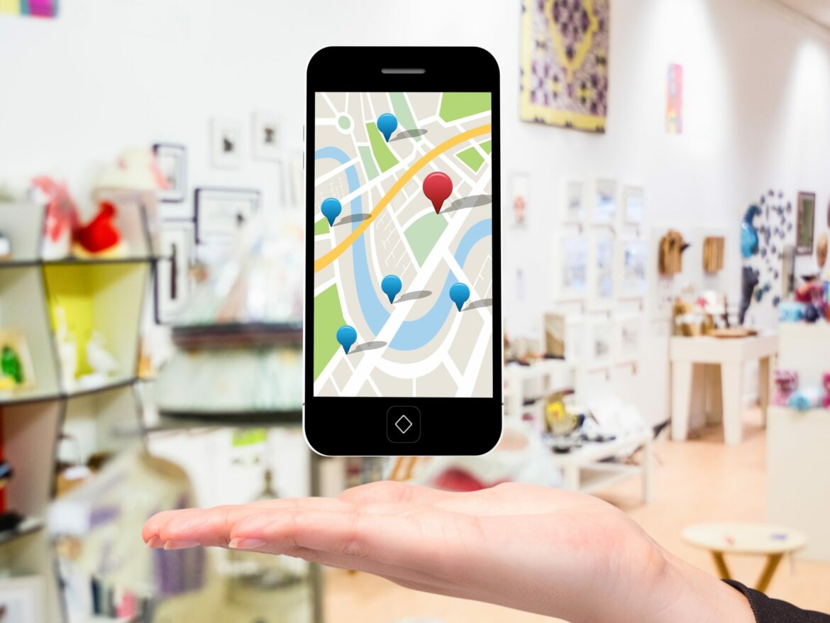 composite of hand holding smartphone with maps graphic with store background