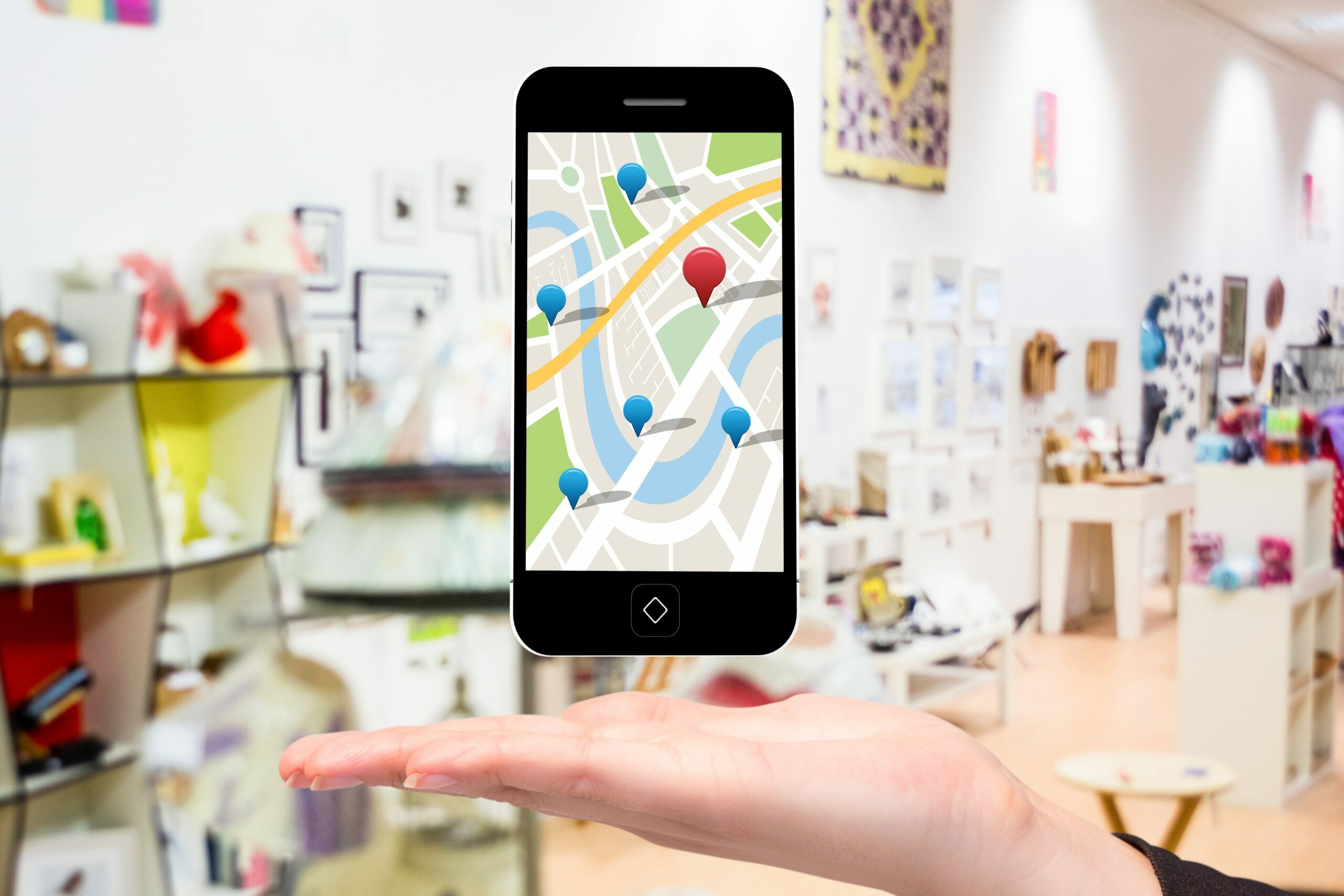 composite of hand holding smartphone with maps graphic with store background